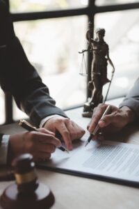 Dos personas firmando un documento