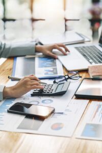 Persona organizando documentos y redactando en una oficina