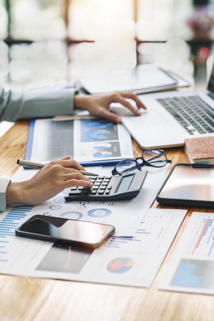 Persona organizando documentos y redactando en una oficina